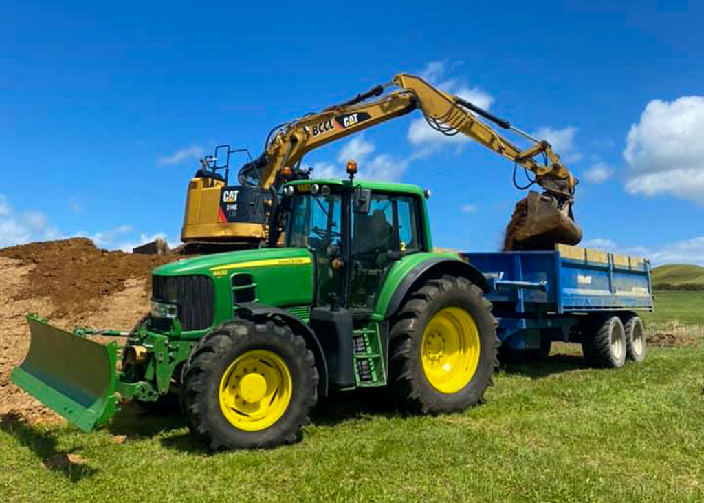 Excavator loading a Hart Contracting tractor and tip trailer